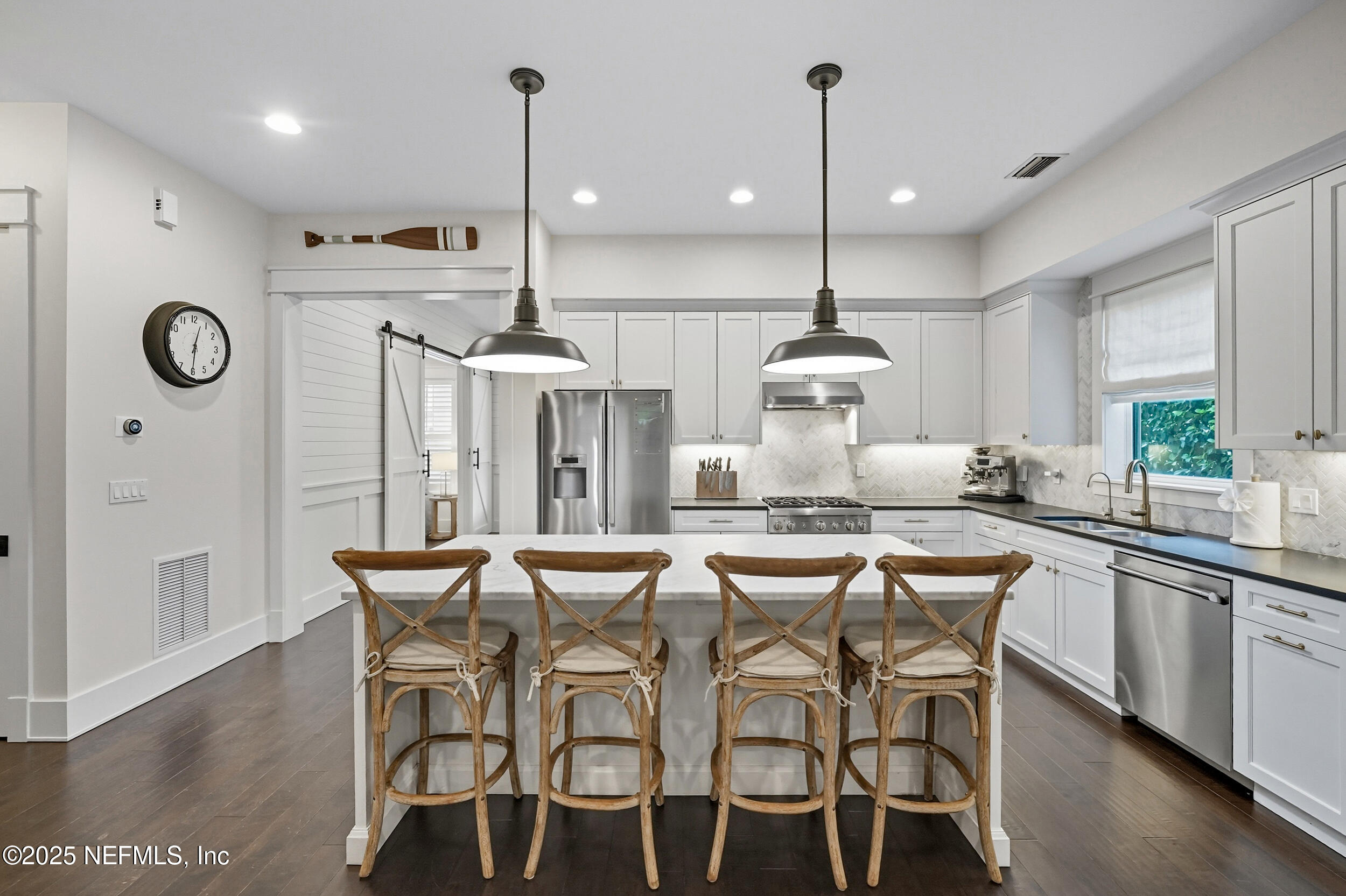 951 Paradise Circle Atlantic Beach, FL 32233 - Photo 17 of 76 a kitchen with stainless steel appliances a dining table chairs sink and cabinets
