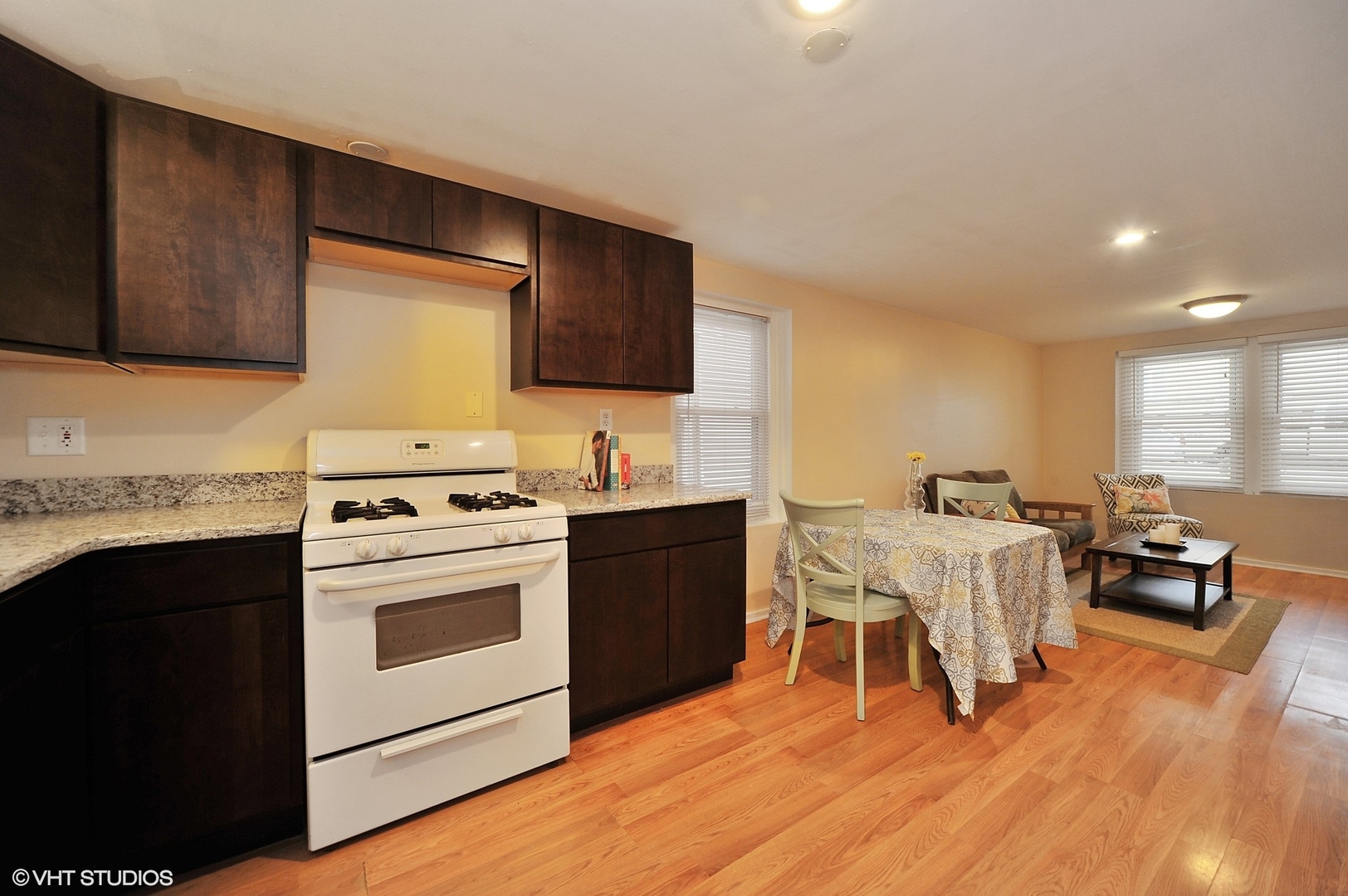 2710 West Fletcher Street Chicago, IL 60618 - Photo 19 of 24 a kitchen with a table chairs a sink dishwasher stove and cabinets with wooden floor