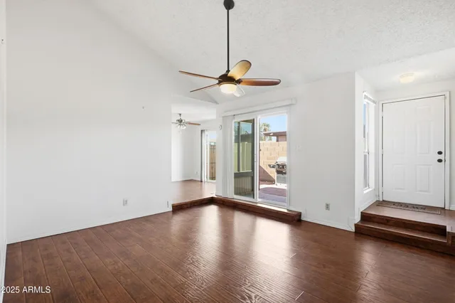 a view of a livingroom with wooden floor and a ceiling fan