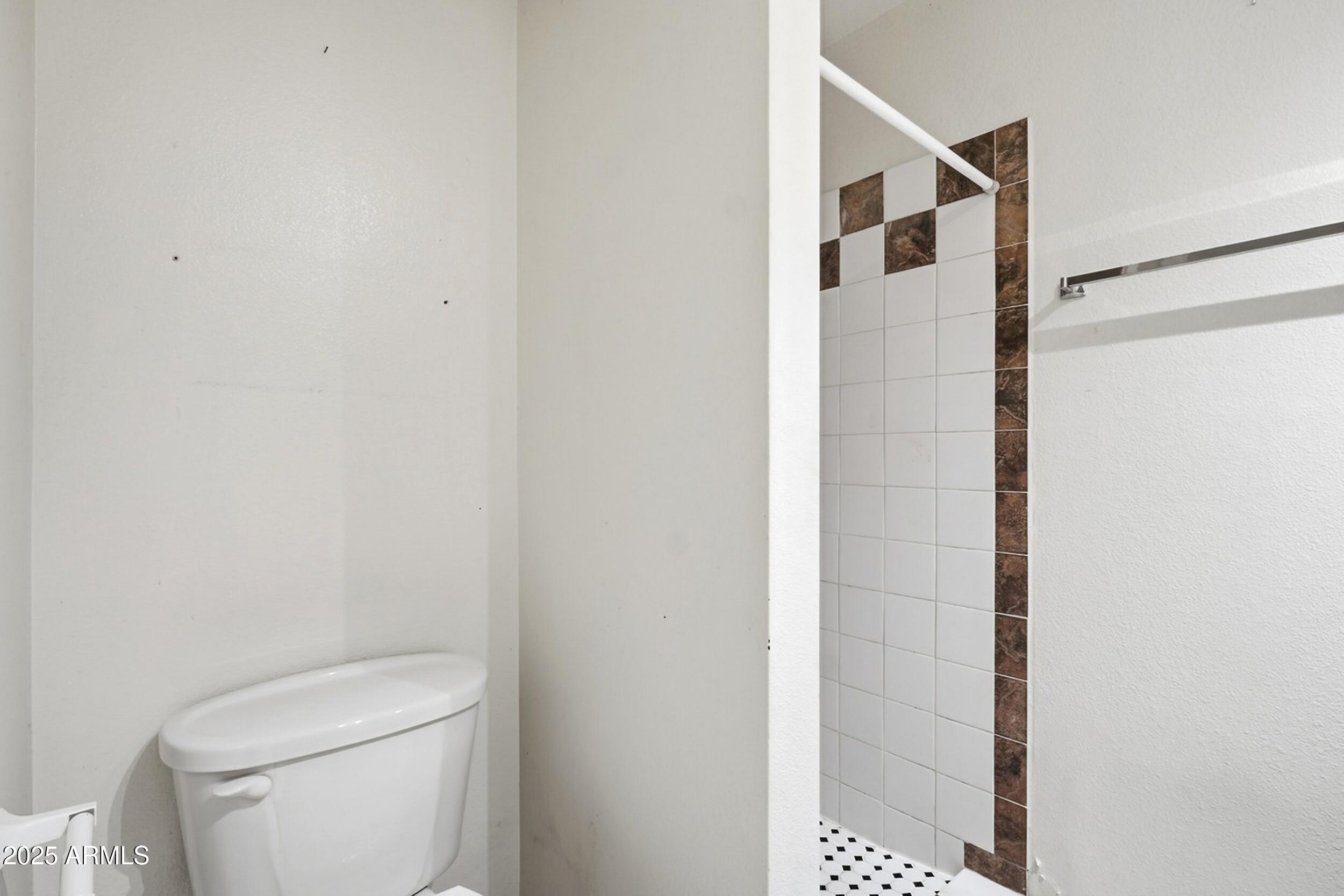 1831 East Kirkland Lane, Unit B Tempe, AZ 85288 - Photo 17 of 33 a white toilet sitting next to a shower curtain