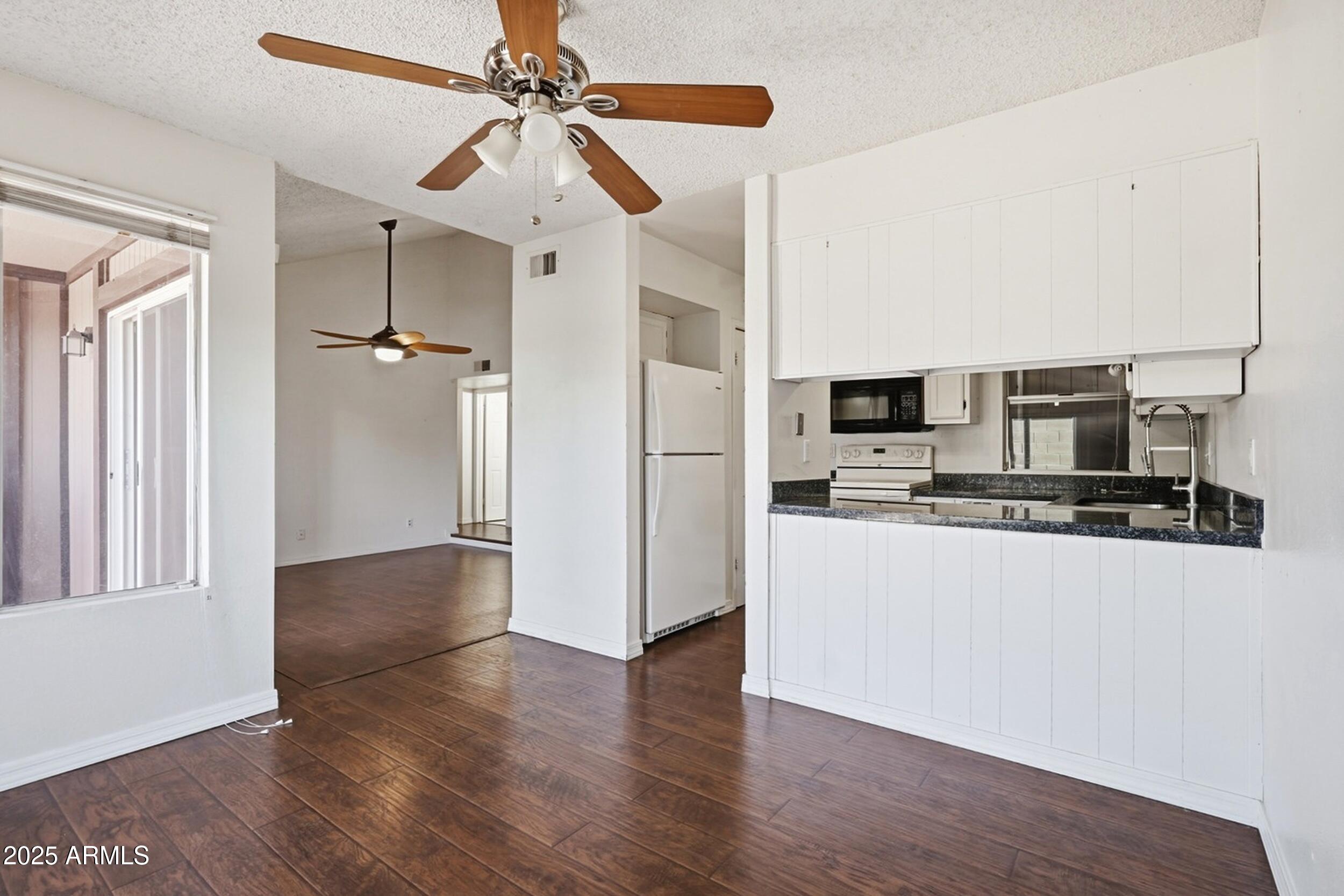 1831 East Kirkland Lane, Unit B Tempe, AZ 85288 - Photo 9 of 33 a view of a kitchen with stainless steel appliances wooden floor and living room view