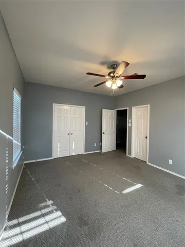 a view of an empty room with a ceiling fan