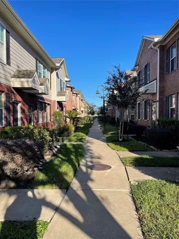 a front view of a house with a yard and potted plants