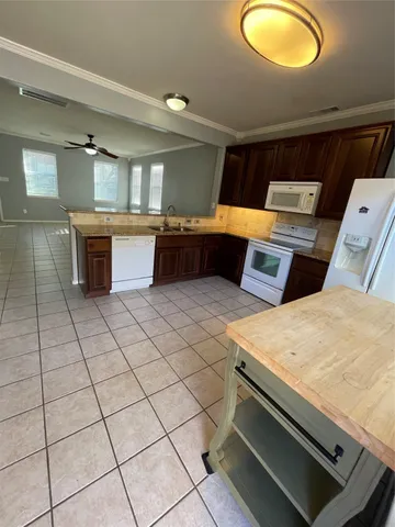 a kitchen with granite countertop a sink and a stove top oven