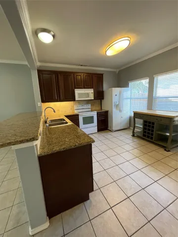a kitchen with granite countertop a stove and a sink