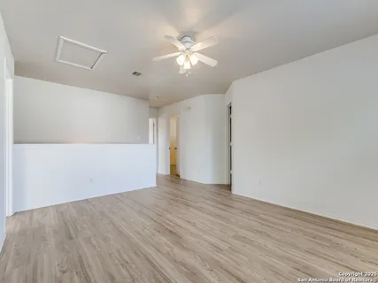 a view of an empty room with wooden floor