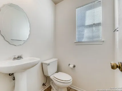 a bathroom with a sink a toilet and a mirror