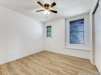 a view of a big room with wooden floor and a chandelier fan
