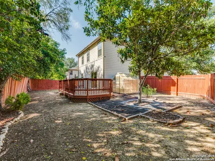 a backyard of a house with a tree and fence