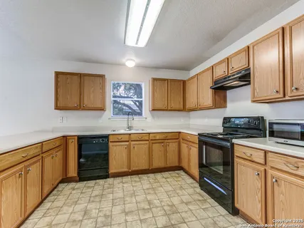 a kitchen with stainless steel appliances granite countertop a sink stove cabinets and a window