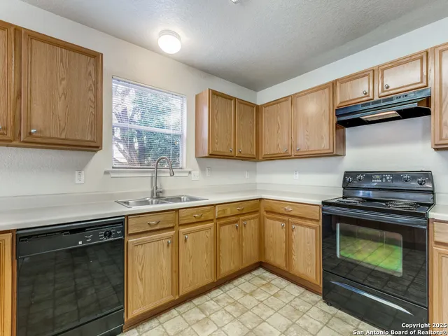 a kitchen with a sink stove and cabinets