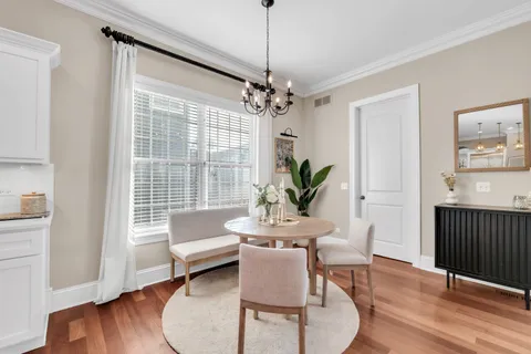 a kitchen with stainless steel appliances kitchen island granite countertop a stove a sink a dining table and chairs