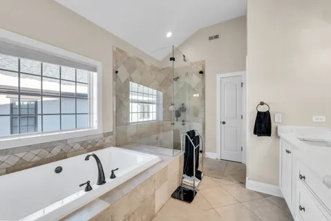 a bathroom with a bathtub and a double vanity sink