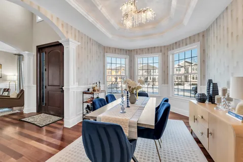 a view of a dining room with furniture a chandelier and wooden floor