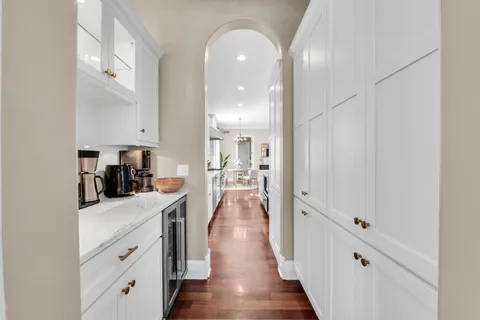 a view of a hallway with wooden floor and a bathroom