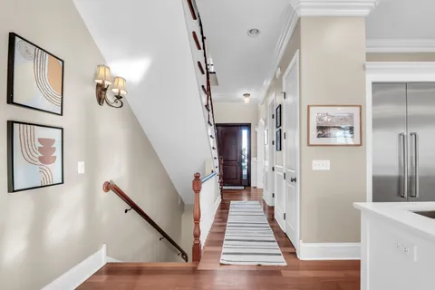 a view of a hallway with wooden floor and staircase