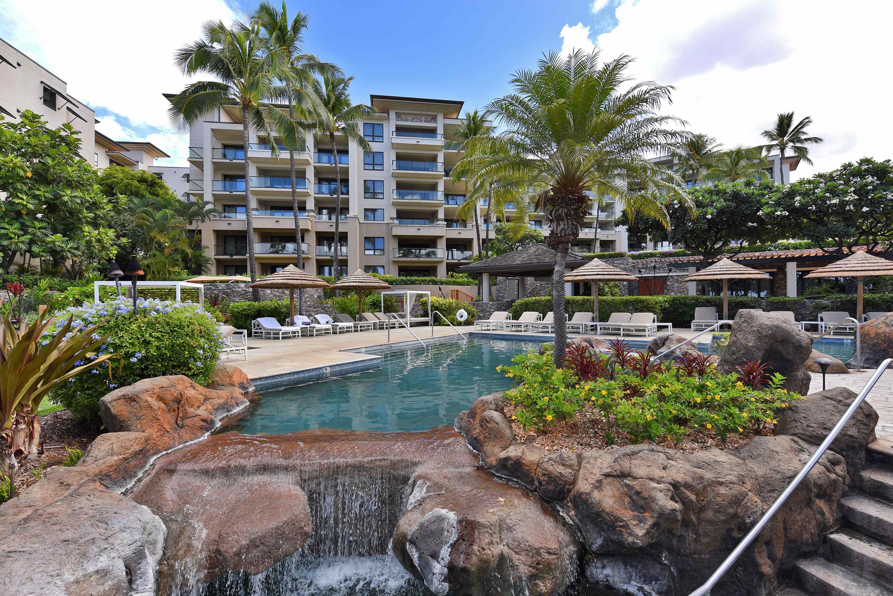1 Bay Drive, Unit 5102 Lahaina, HI 96761 - Photo 43 of 50 a view of a swimming pool with lawn chairs and plants