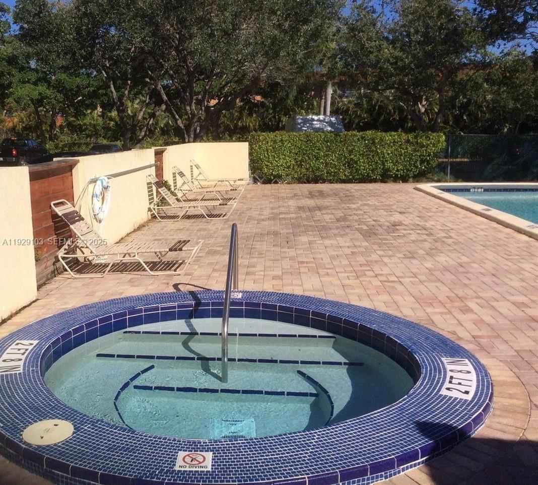 2501 Riverside Drive, Unit 207A Coral Springs, FL 33065 - Photo 4 of 4 a swimming pool with lawn chairs and wooden fence