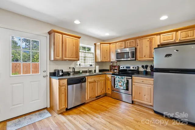 a kitchen with stainless steel appliances granite countertop a stove a sink and a refrigerator