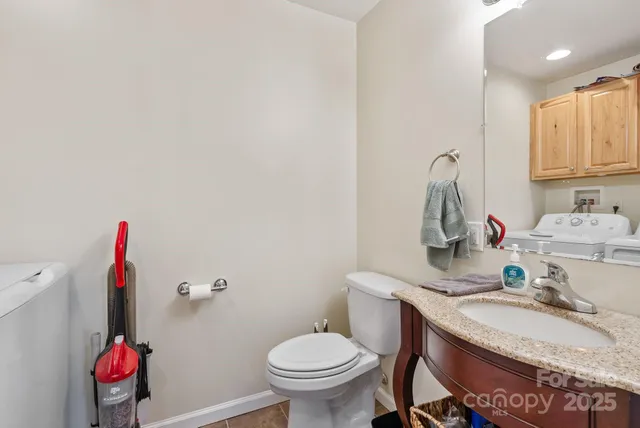 a bathroom with a granite countertop sink and a toilet