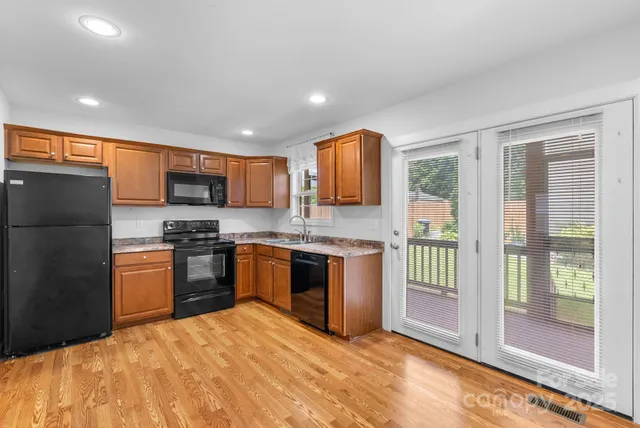 a kitchen with stainless steel appliances granite countertop a refrigerator stove top oven and sink