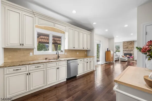 a bathroom with a granite countertop sink a toilet a large mirror and a window