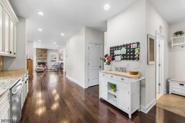 a view of a hallway with wooden floor and a living room