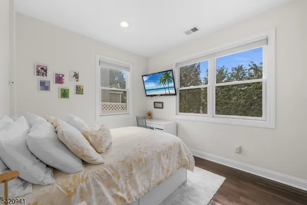 a bedroom with furniture and wooden floor