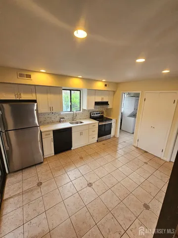 a kitchen with stainless steel appliances granite countertop a refrigerator sink and cabinets