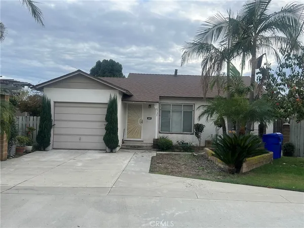 a view of a house with a yard and palm trees