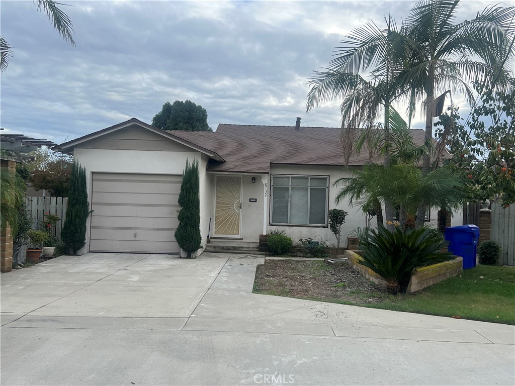 a view of a house with a yard and palm trees
