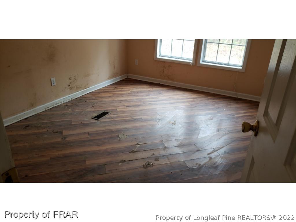 272 Town Branch Road Vass, NC 28394 - Photo 19 of 20 a view of an empty room with wooden floor and a window