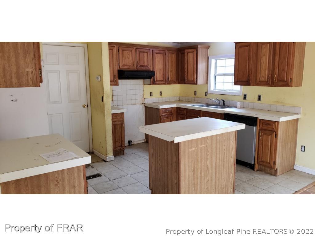 272 Town Branch Road Vass, NC 28394 - Photo 7 of 20 a kitchen with stainless steel appliances a sink a stove a refrigerator cabinets and a window