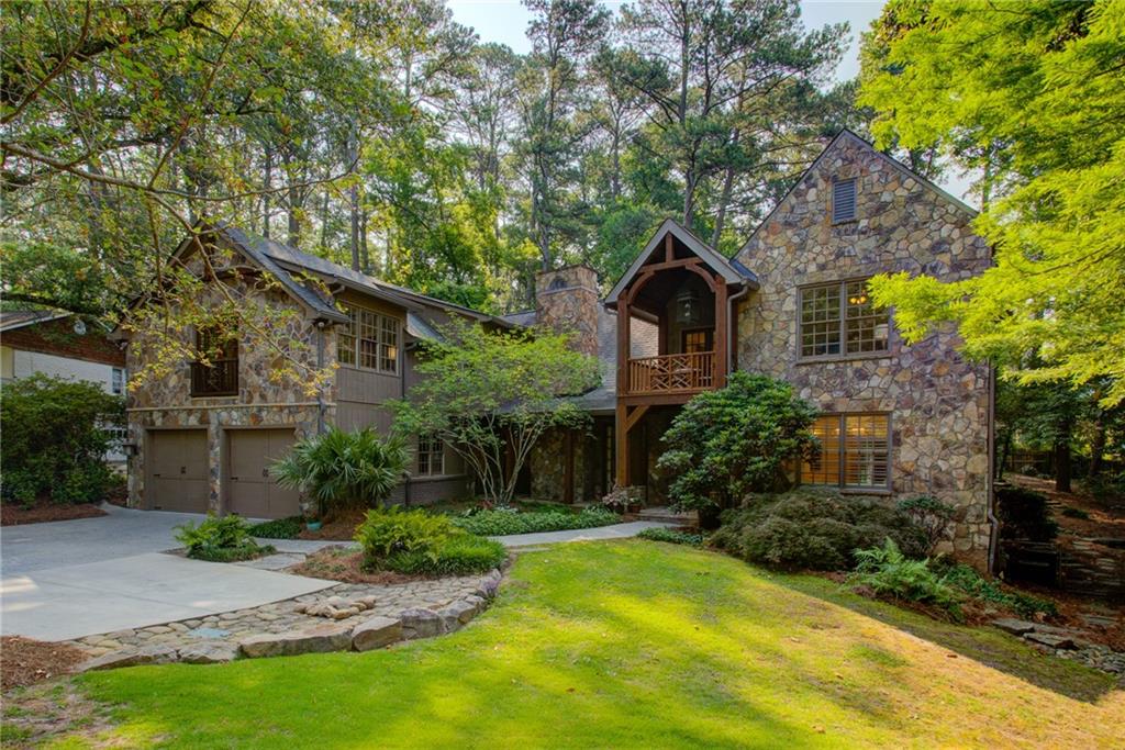 a front view of a house with a yard and tree s