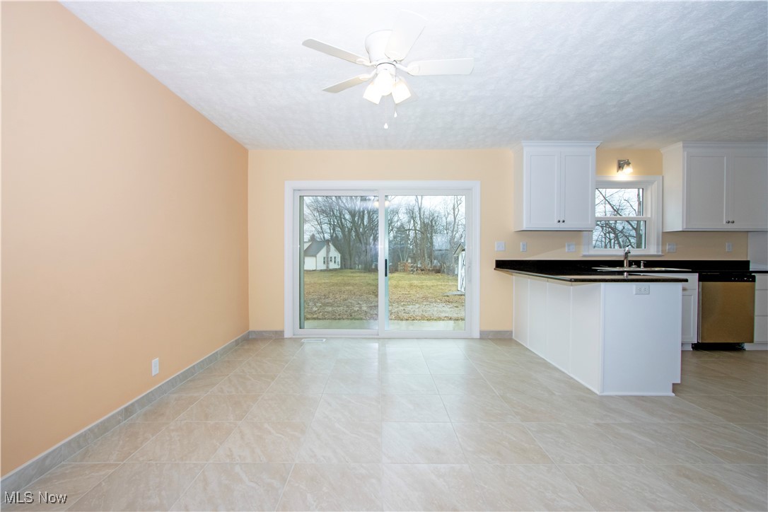 2467 Shreve Road Wooster, OH 44691 - Photo 6 of 27 Kitchen featuring a textured ceiling, ceiling fan, white cabinets, stainless steel dishwasher, and dark countertops
