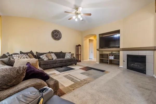 a living room with furniture a fireplace and a flat screen tv