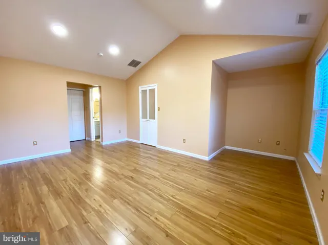 a view of empty room with wooden floor