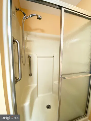 a bathroom with a shower and a glass shower door
