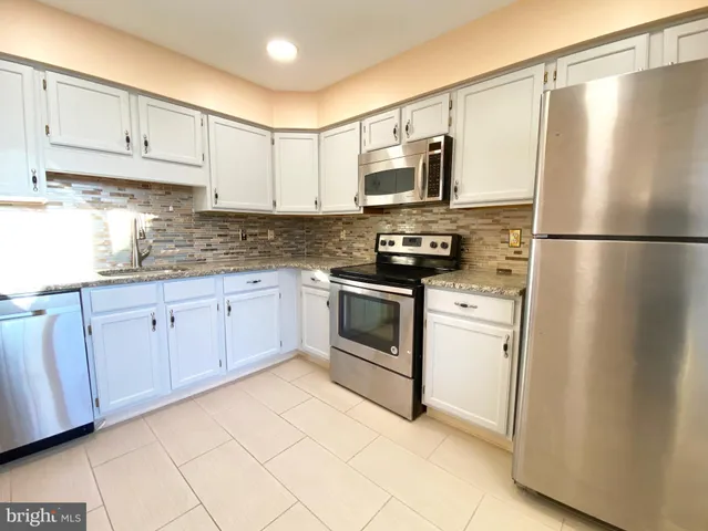 a kitchen with stainless steel appliances a refrigerator sink and cabinets