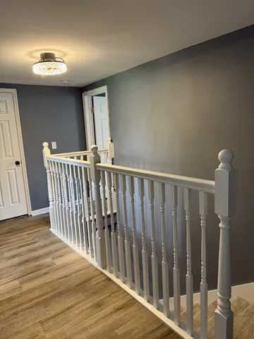 a view of a hallway with wooden floor and stairs