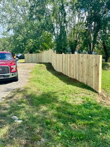 a view of a yard with a car parked in front of it