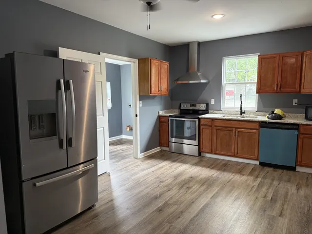 a kitchen with stainless steel appliances granite countertop a refrigerator stove and sink