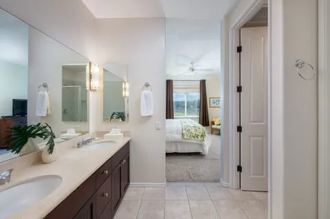 a bathroom with a double vanity sink mirror and shower