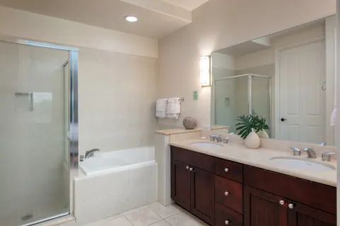 a bathroom with a tub double sink and mirror