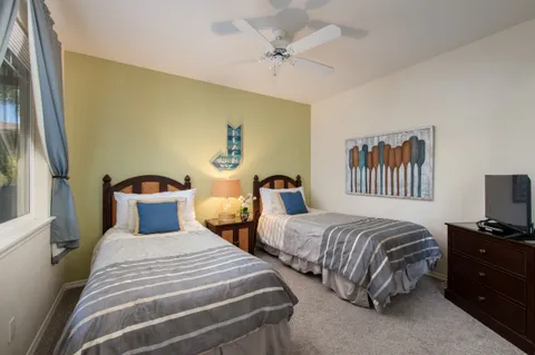 a bedroom with two beds and a chandelier