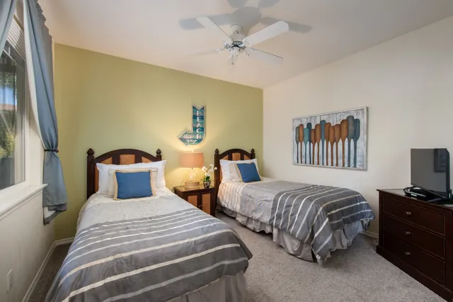a bedroom with two beds and a chandelier