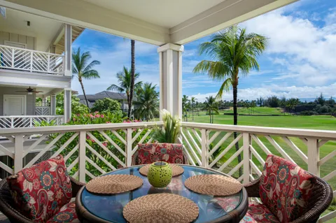 a view of a balcony with chairs and a potted plant