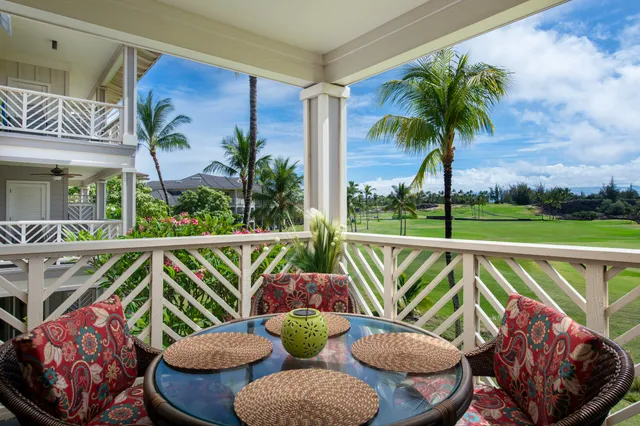 a view of a balcony with chairs and a potted plant