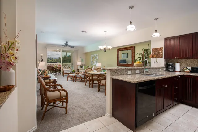 a kitchen with sink refrigerator and chairs
