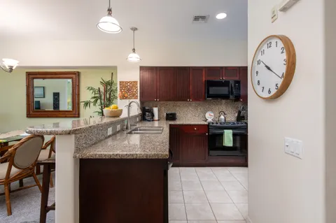 a kitchen with granite countertop a sink a stove and cabinets